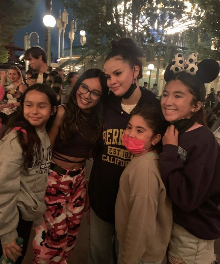 Group of young girls posing together at night in an amusement park